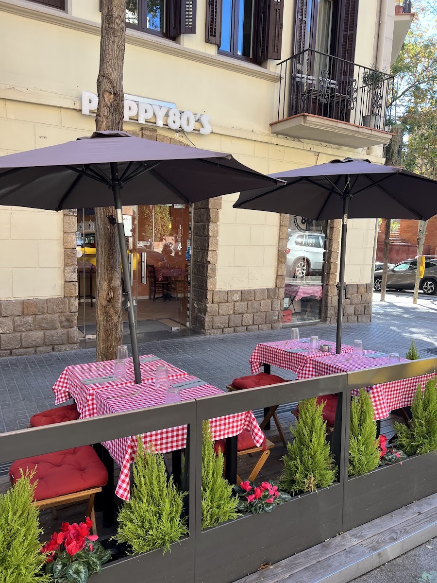 Terraza exterior con manteles a cuadros rojos y sombrillas negras