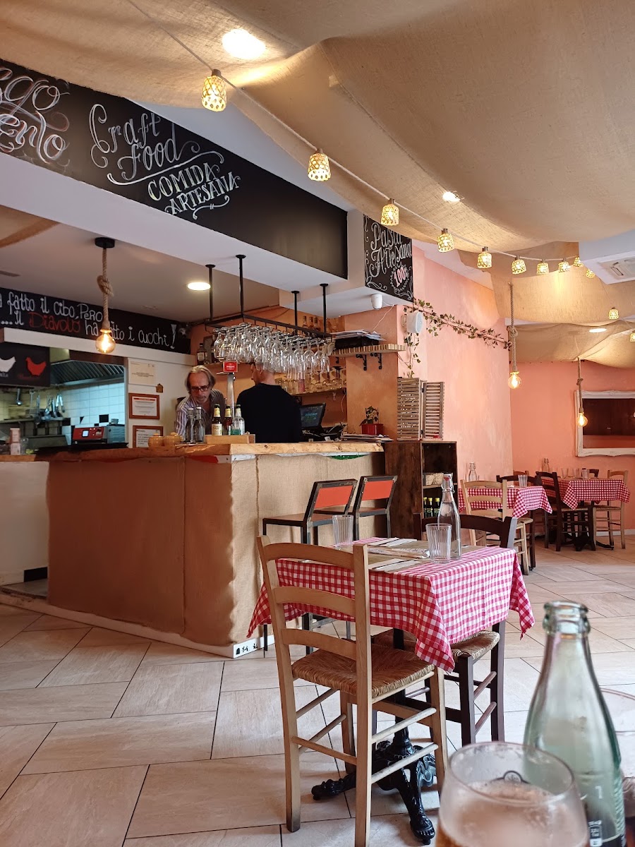Comedor interior con barra, manteles a cuadros y luces de guirnaldas